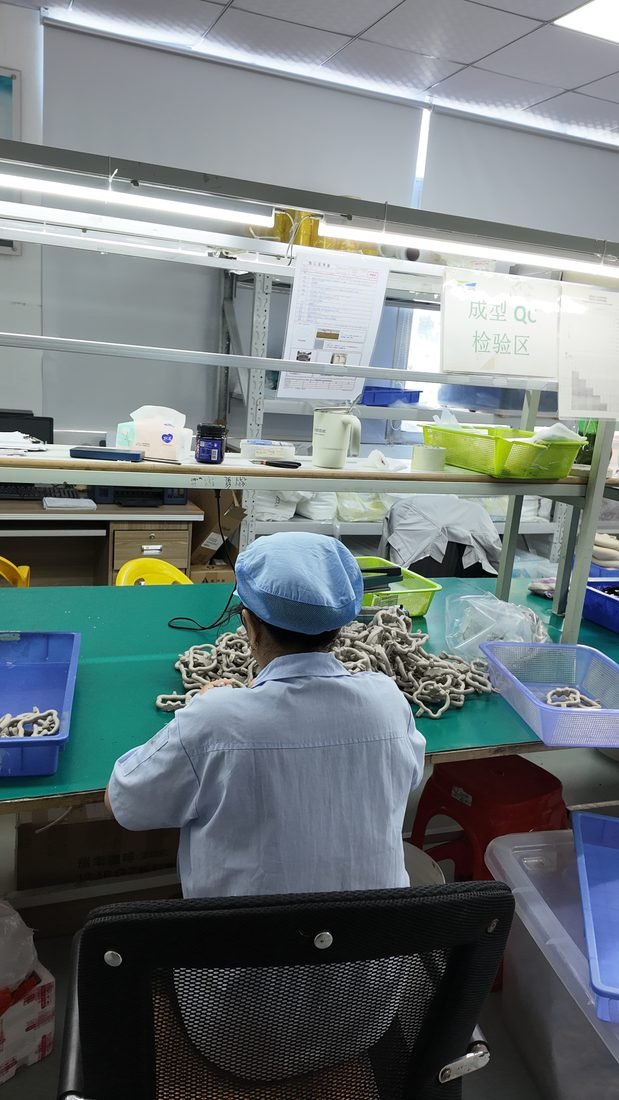Worker inspecting and finishing silicone parts